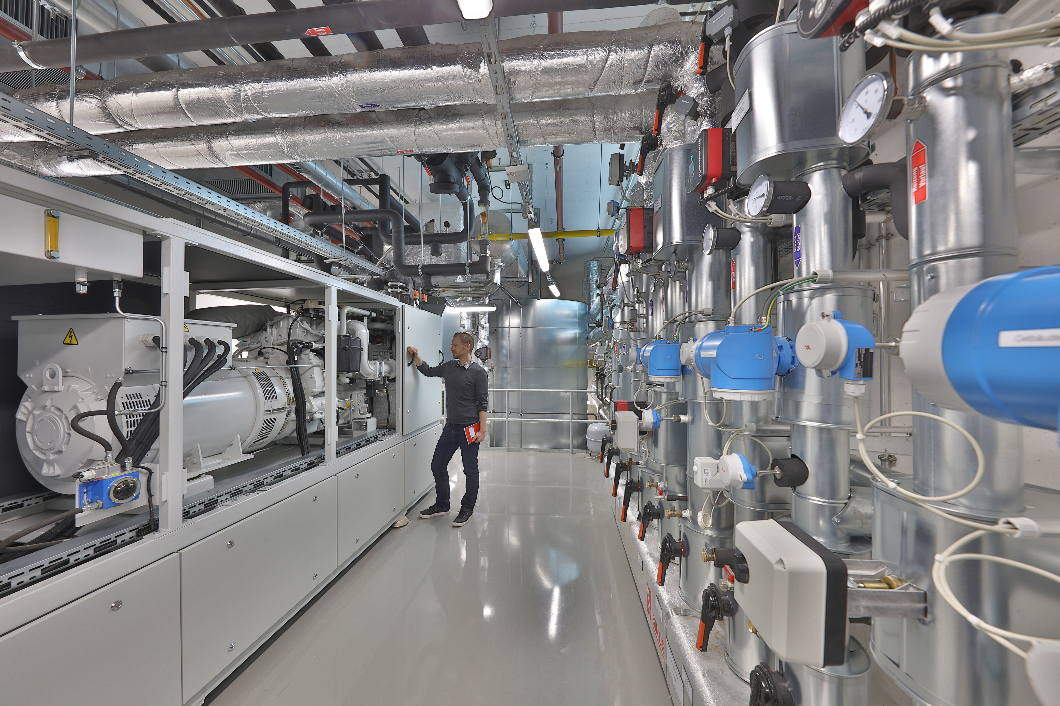 Blockheizkraftwerk und Warmwasserspeicher im Keller des Fraunhofer IISB: Die Kraftwärme-Kopplungsanlage wurde im Rahmen des Erweiterungsbaus B in die Infrastruktur des Instituts integriert. Dort wird sie sowohl zur Wärme- und Stromversorgung als auch als Forschungsanlage genutzt. Blockheizkraftwerk und Warmwasserspeicher im Keller des Fraunhofer IISB: Die Kraftwärme-Kopplungsanlage wurde im Rahmen des Erweiterungsbaus B in die Infrastruktur des Instituts integriert. Dort wird sie sowohl zur Wärme- und Stromversorgung als auch als Forschungsanlage genutzt.