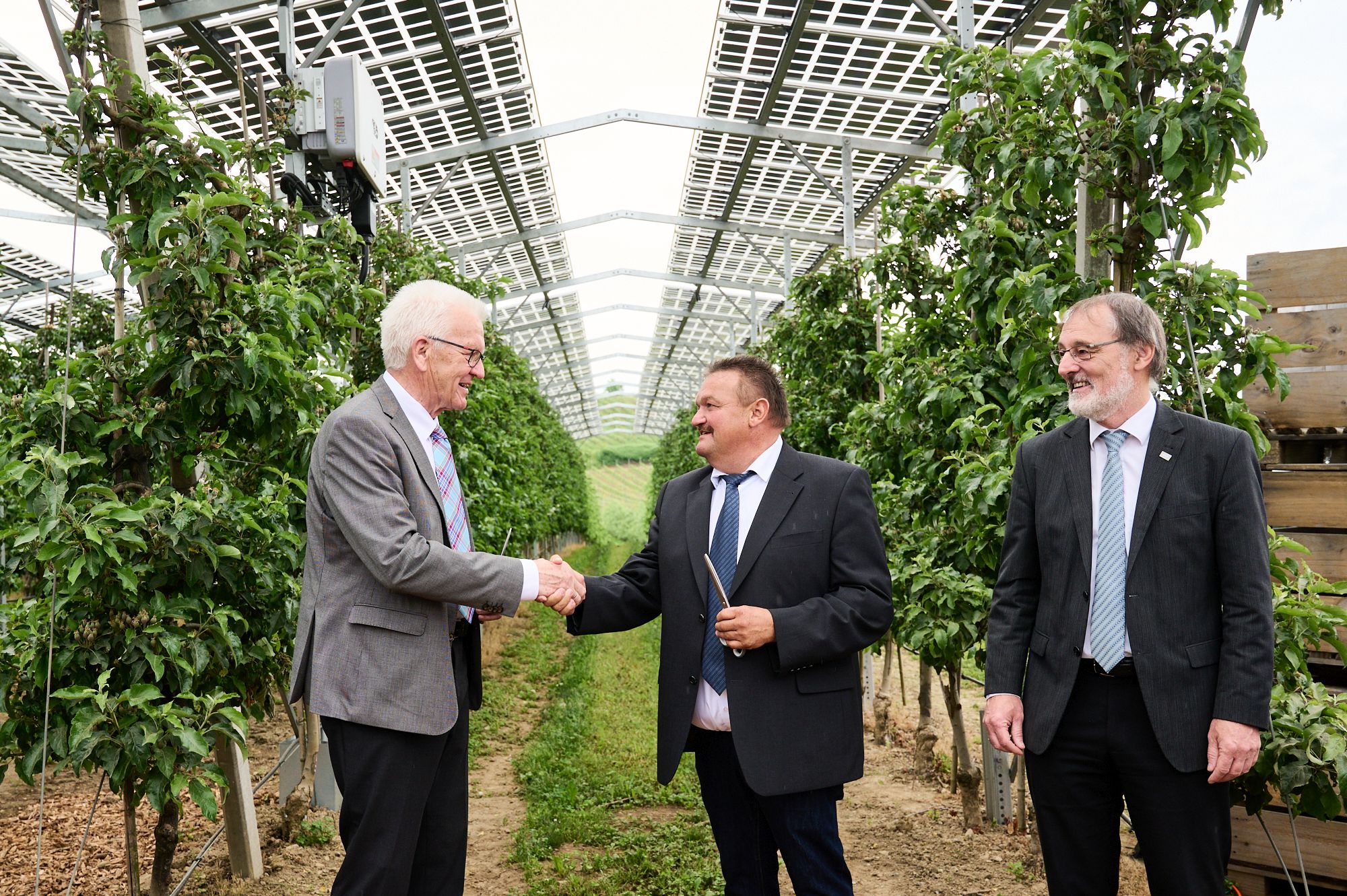 Baden-Württembergs Ministerpräsident Winfried Kretschmann, Landwirt Hubert Bernhard und Prof. Andreas Bett, Leiter des Fraunhofer-Instituts für Solare Energiesysteme, weihten die Agri-Photovoltaikanlage in Kressbronn ein. Baden-Württembergs Ministerpräsident Winfried Kretschmann, Landwirt Hubert Bernhard und Prof. Andreas Bett, Leiter des Fraunhofer-Instituts für Solare Energiesysteme, weihten die Agri-Photovoltaikanlage in Kressbronn ein.