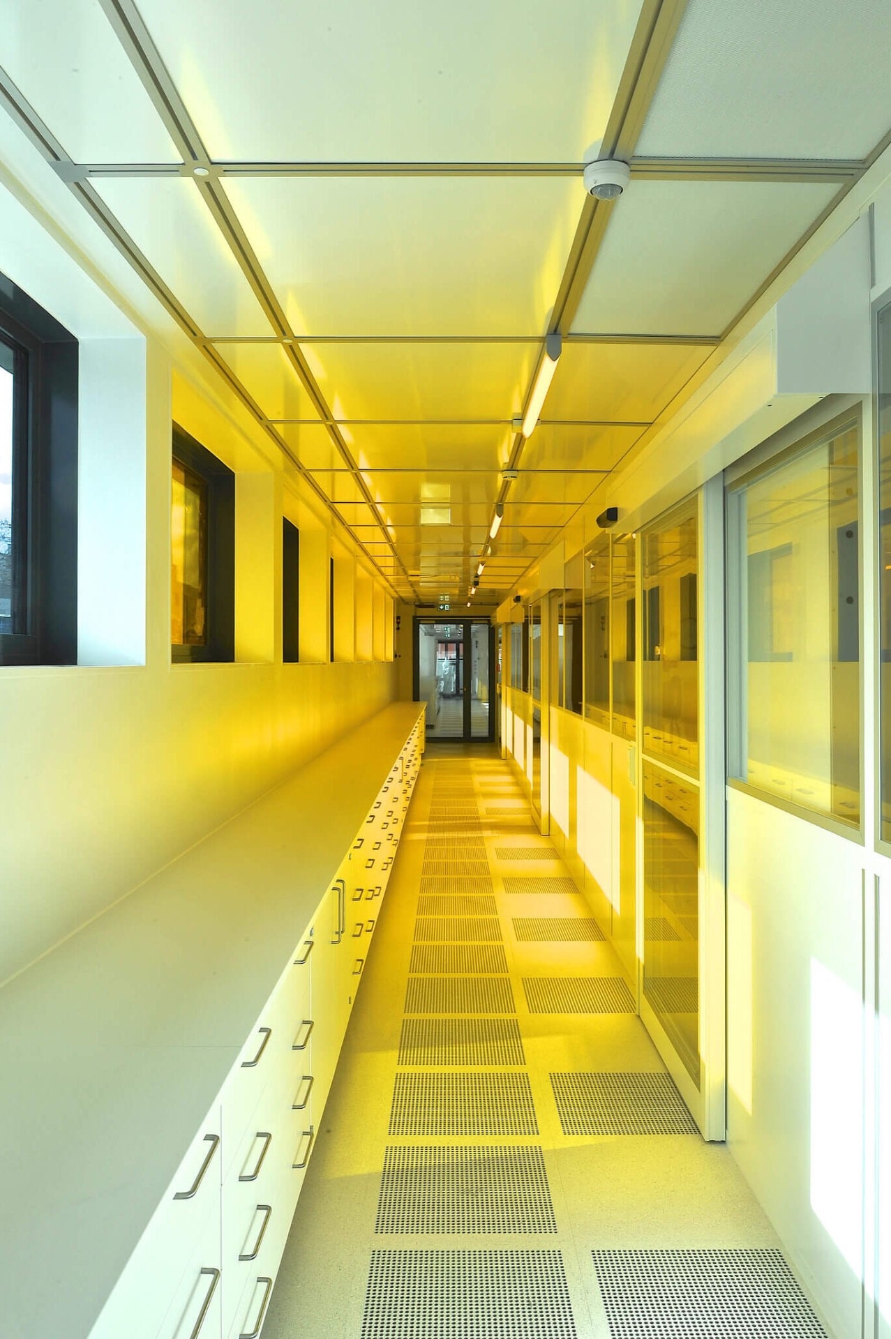 Center for High Efficiency Solar Cells: View into the corridor of the clean room. In the back one can see the yellow light from the photolithography laboratory.