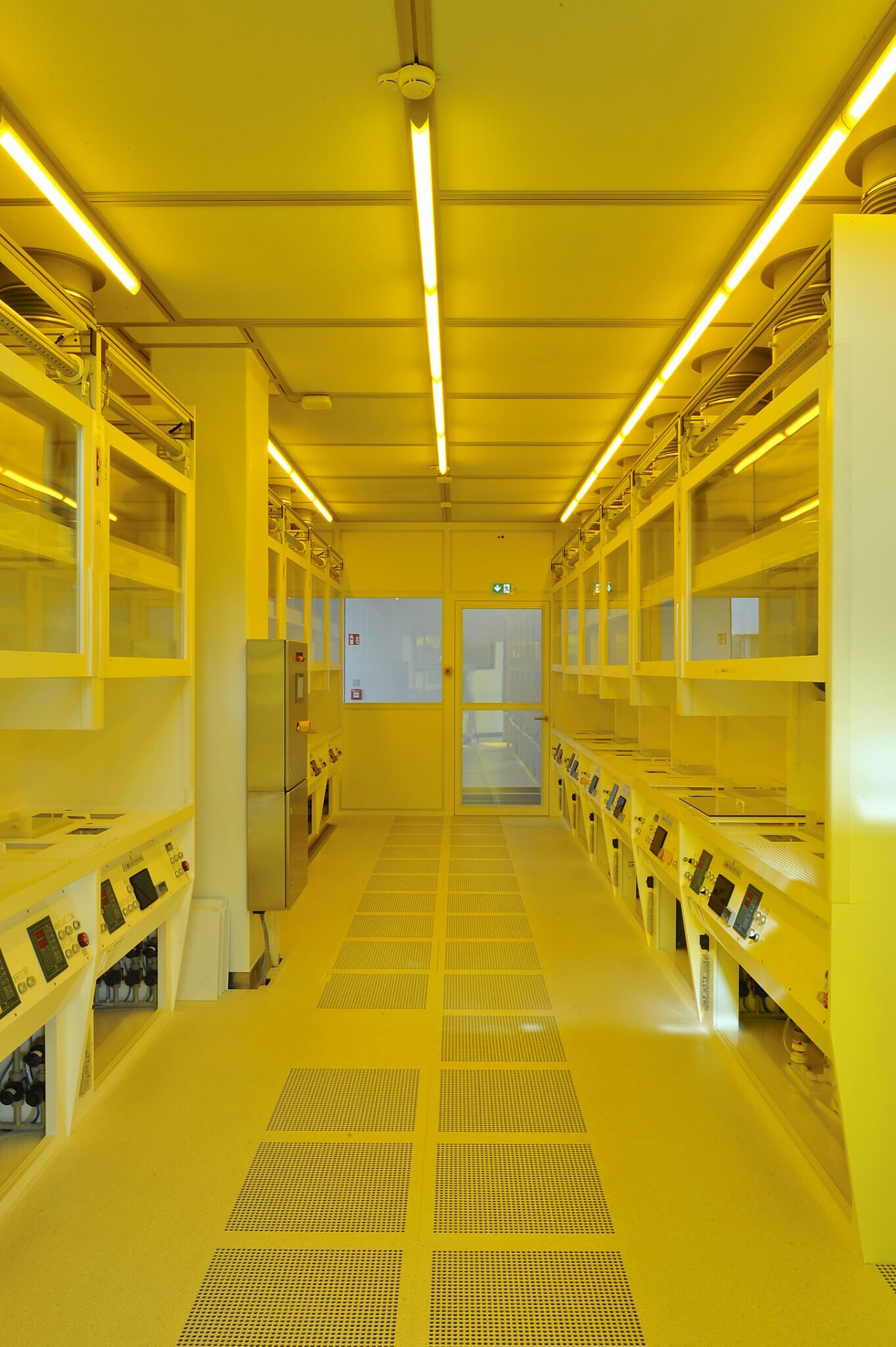 View into the clean room of the Center for High Efficiency Solar Cells. The filtered air coming from the ceiling can efficiently flow out through the perforated floor tiles, creating an especially clear atmosphere.